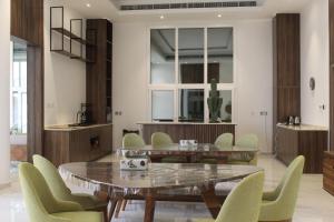 een eetkamer met een tafel en groene stoelen bij Masfout Mountains View in Sinādil