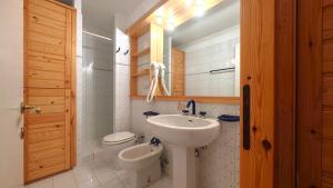 une salle de bains avec lavabo et toilettes dans l'établissement Hostdomus- Abeti Apartments, à Sestrières 65 autres photos