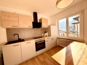 a kitchen with white cabinets and a sink and a window at Gruber Alpin Living in Söll