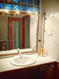 een badkamer met een wastafel en een grote spiegel bij CASA VACANZA Emma in Monfalcone +30 foto's