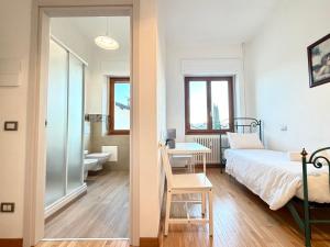 una camera da letto con un letto, una scrivania e un bagno di Negrar Cuore Rooms a Negrar