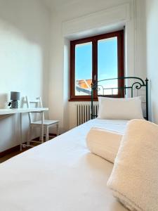 una camera con letto, scrivania e finestra di Negrar Cuore Rooms a Negrar Altre 8 foto