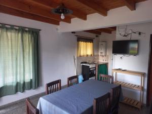 a room with a table with chairs and a television at Lo de la Abu in Villa Las Rosas