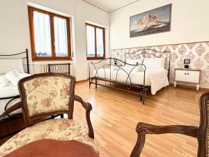 una camera da letto con due letti e una sedia di Negrar Cuore Rooms a Negrar