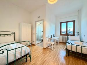 una camera da letto con due letti, un tavolo e una scrivania di Negrar Cuore Rooms a Negrar