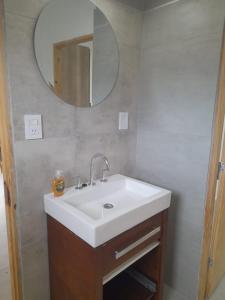 een badkamer met een witte wastafel en een spiegel bij Casa Aramí in Victoria