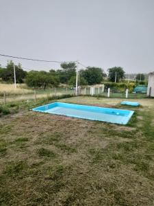 a blue swimming pool in the middle of a field at Casa Aramí in Victoria +3 photos