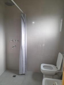 een witte badkamer met toilet en douche bij Casa Aramí in Victoria