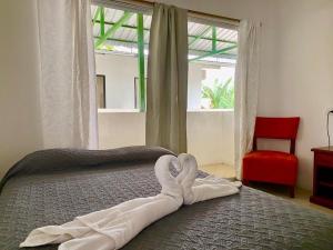 a bed with a towel on it with a window at Hostería "El Paraíso" in Montañita +41 photos