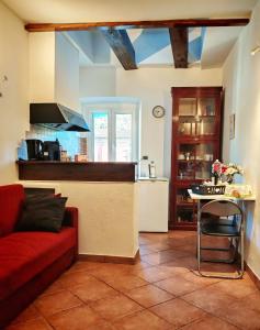 een woonkamer met een rode bank en een keuken bij CASA VACANZA Emma in Monfalcone