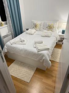 a white bed with towels on it in a room at Apartman Vuk in Vrnjačka Banja +22 photos