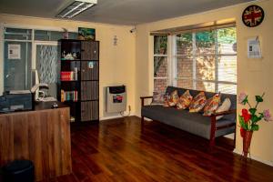 a living room with a couch and a book shelf at Hostal Turpial Patagonia in Puerto Natales