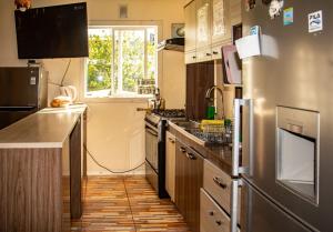 a kitchen with stainless steel appliances and a window at Hostal Turpial Patagonia in Puerto Natales