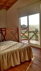 una camera da letto con un letto e una grande finestra di Cabaña Marilau a Santa Clara del Mar