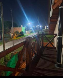 un portico di legno con una recinzione e una strada di notte di Cabaña Marilau a Santa Clara del Mar