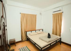 een slaapkamer met een bed met een kussen erop bij Orlardee hostel in Thakhek