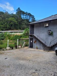 a building with a staircase next to a parking lot at Studio com hidromassagem em Guararema in Guararema