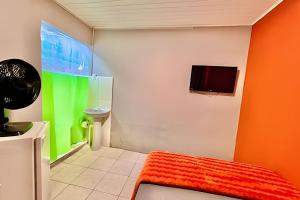 un bagno con una parete arancione e verde di Pousada Meu Cantinho a Matinhos