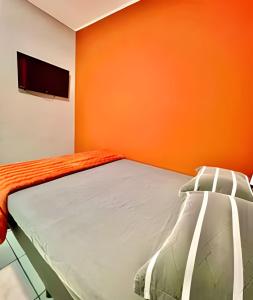 un letto in una stanza con una parete arancione di Pousada Meu Cantinho a Matinhos