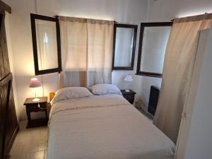 una camera da letto con un letto grande con due finestre di La mary a Villa Gesell Altre 21 foto