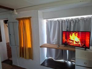 una TV appoggiata su una finestra con un fuoco acceso di La mary a Villa Gesell