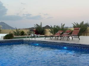 two chairs sitting next to a swimming pool at Moonlight Resort in Sinādil