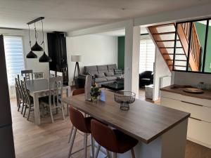 une cuisine et un salon avec une table et des chaises dans l'établissement Maison bord de mer normandie, à Langrune-sur-Mer