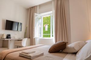 een slaapkamer met een bed, een raam en een bureau bij Santa Lucia Suites in Padua