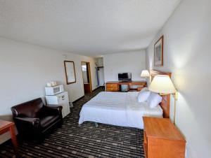 een hotelkamer met een bed en een stoel bij Ponderosa Motel in Goldendale