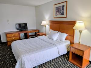 een hotelkamer met een bed en een televisie bij Ponderosa Motel in Goldendale