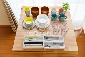a table with glasses and plates and utensils on it at 民泊 Ichinomiya K Room 1A in Ichinomiya