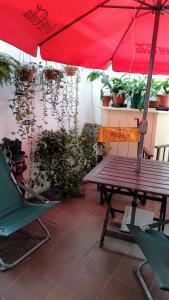 een rode parasol, een picknicktafel en een stoel bij Palermo Candombe House in Montevideo