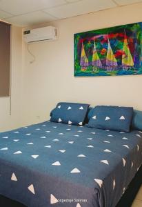 a bedroom with a bed and a painting on the wall at Riveri Salinas V53 in Salinas