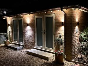 een bakstenen huis met een voordeur met verlichting bij NEW New Forest Hideaway for Two in Brockenhurst +7 foto's