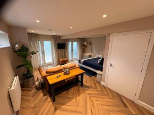 een woonkamer met een bank en een tafel bij NEW New Forest Hideaway for Two in Brockenhurst