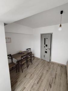 ein leerer Raum mit einem Tisch und Stühlen und einer Tür in der Unterkunft Apartament Alessi Home in Călimăneşti