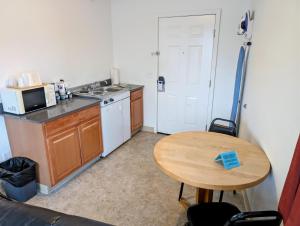 een kleine keuken met een houten tafel en een klein tafeltje bij Ponderosa Motel in Goldendale +6 foto's