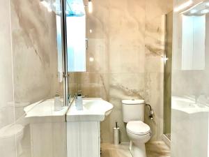 a white bathroom with a sink and a toilet at VASKO Luxury Suites 4 in Siátista +10 photos
