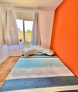 a bed in a room with an orange wall at BriSa Do Mar < Flecta Matinhos in Matinhos