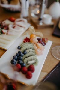 a white plate topped with fruit on a wooden table at Mesnerhaus & Gourmetrestaurant Mesnerhaus mit 4 Hauben in Mauterndorf +55 photos
