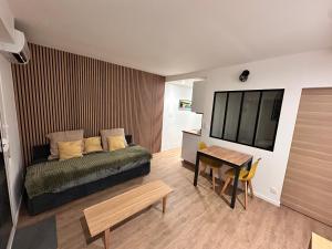 een slaapkamer met een bed, een tafel en een televisie bij Ocean et Golf in Anglet