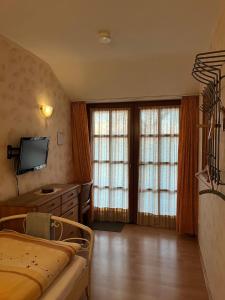 ein Schlafzimmer mit einem Bett und zwei großen Fenstern in der Unterkunft Weingut Günther und Gästezimmer 