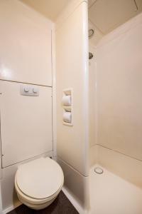 a white bathroom with a toilet and a shower at ibis Budget - Newcastle in Newcastle