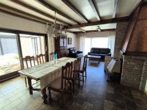a dining room with a table and chairs and a couch at Willa Sunny Garden in Sint-Laureins