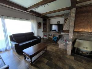 a living room with a couch and a fireplace at Willa Sunny Garden in Sint-Laureins