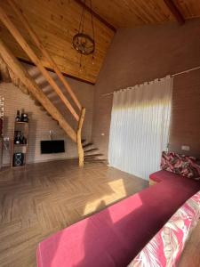 een woonkamer met een bed en een houten plafond bij Rancho Pedacinho de Coração in Itamonte