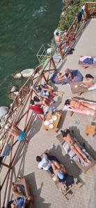 un gruppo di persone seduti su un molo vicino all'acqua di San Jerónimo River Lodge a Lunahuaná