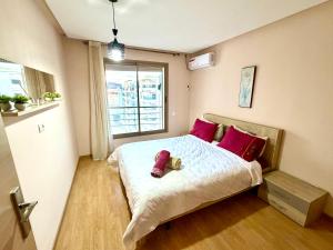 a small bedroom with a bed with red pillows at Appartement avec vue sur parc et Wifi 100 Mo illimité ! in Fez