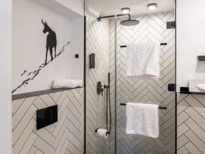 a bathroom with a shower with a black cat on the wall at GRETI - Alpine Boutique Hotel mit Alpentherme Eintritt, reichhaltigem Frühstück, Sauna in Bad Hofgastein