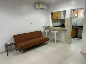 een woonkamer met een bank en een keuken bij Mobile doctors apartment in Accra